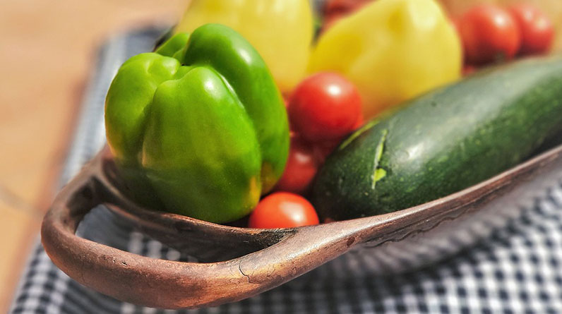 Organic vegetables in a bowl on a checkered tablecloth.